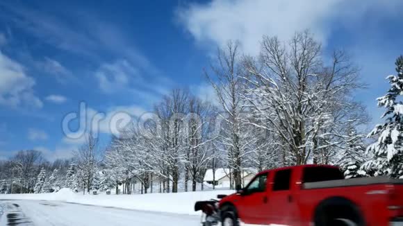 暴风雪过后一个住宅区的橡树在房屋前的积雪堆前结了新雪视频的预览图