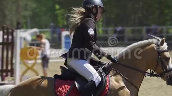 慢动作一位年轻女子骑着一匹小马驹在马术比赛中表演视频的预览图
