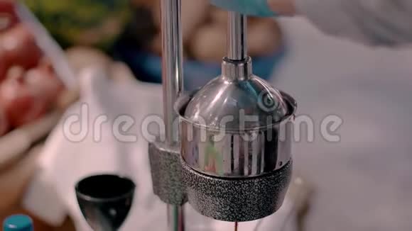 机械榨汁机榨汁的过程特写过程果汁倒入杯中视频的预览图