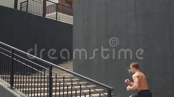 白人运动员在城市楼梯上用能量向上奔跑视频的预览图