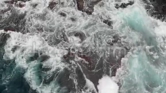 上景陡峭的火山海岸冰封的火山熔岩的礁石暴风雨般的海洋来自巨浪的白色泡沫视频的预览图