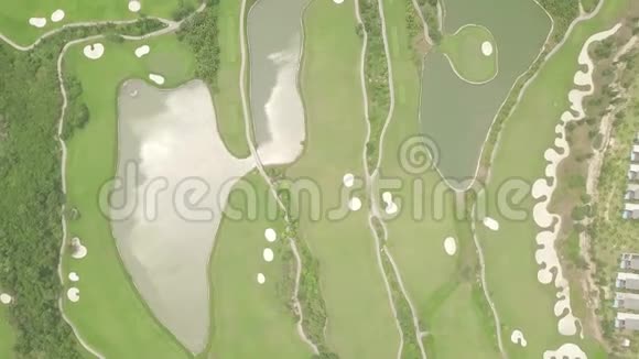从飞行无人机俯瞰豪华高尔夫球场和湖泊的绿色草坪现代空中景观绿地与湖泊视频的预览图