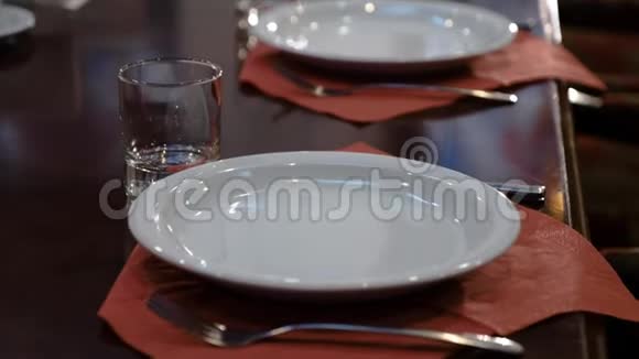 大而别致的抛光桌子上面有盘子和眼镜贵族餐厅的餐桌布置视频的预览图