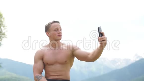 男人拿着智能手机在山上的户外自拍视频的预览图