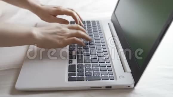 紧紧抓住女商人的手她正躺在旅馆的床上用手提电脑键盘打字视频的预览图