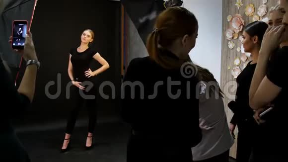 年轻女子模特在摄影棚拍照穿着黑色衣服射杀模特全高射击视频的预览图