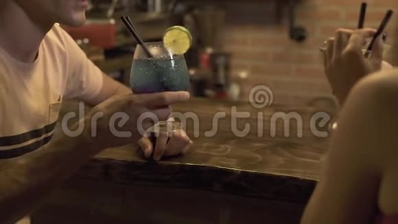 男人和女人坐在酒吧柜台喝着酒精鸡尾酒晚上在咖啡馆约会年轻夫妇喝酒视频的预览图