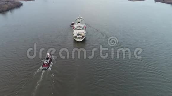 拖船引导冷藏船进入港口的空中足迹视频的预览图
