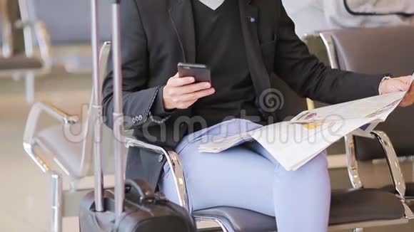 男性手中的特写智能手机和机场内的报纸穿西装外套的休闲年轻商人青年视频的预览图