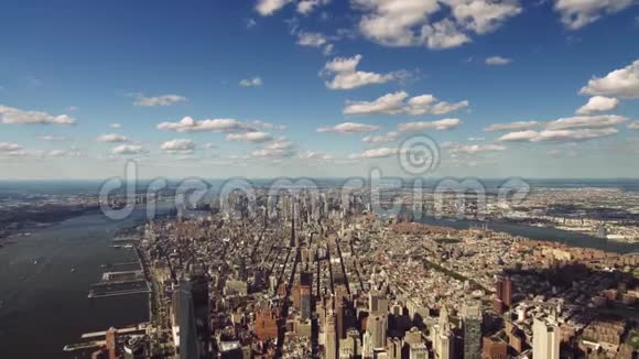 明亮的蓝色多云的天空笼罩着纽约市中心的现代建筑美丽的空中天际线全景视频的预览图