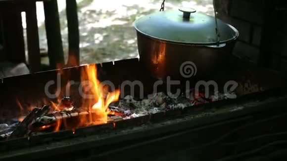 汤或其他食物的盛锅挂在柴火和煤上视频的预览图