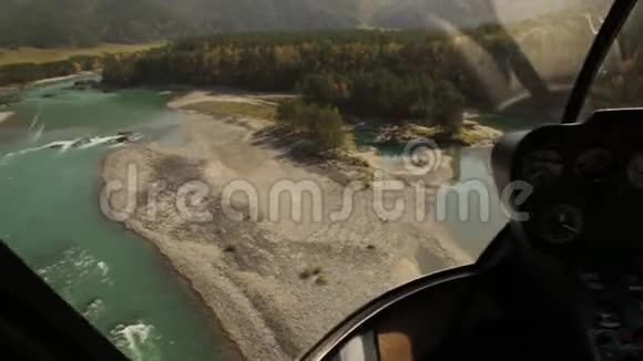 从直升机驾驶舱看到低空飞行直升机飞越山区河床视频的预览图