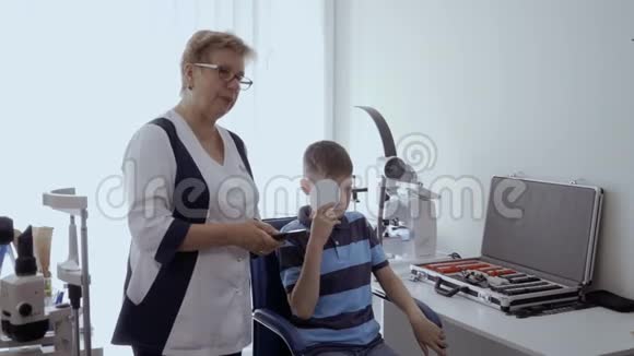 医生检查男孩光学实验架的视力视频的预览图