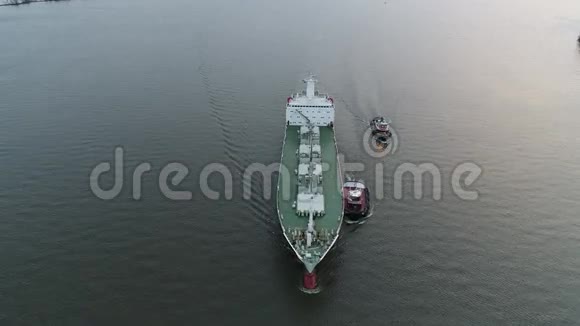 拖船引导冷藏船进入港口的空中足迹视频的预览图