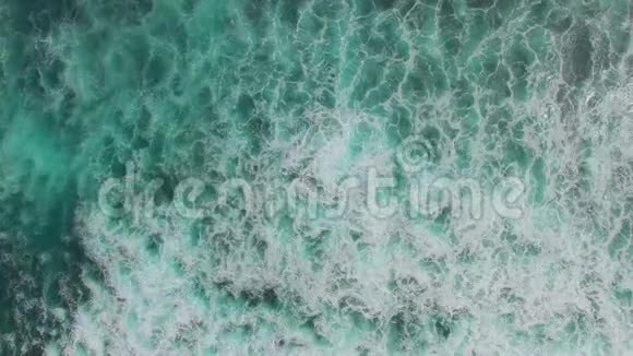 海洋蓝波撞击海岸线无人机镜头的俯视图视频的预览图