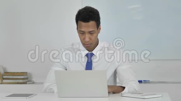 戴头巾的美国黑人商人在笔记本电脑上工作视频的预览图