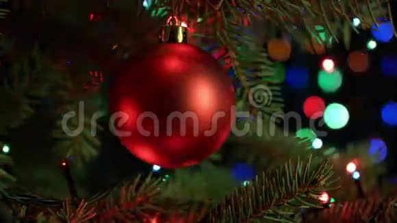 圣诞节和新年装饰圣诞树上装饰着红色的球有模糊的仙女灯花环视频的预览图