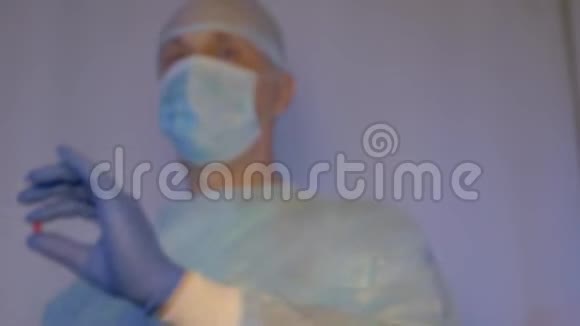 医生戴着医用口罩出示一颗红色药丸给病人服用视频的预览图