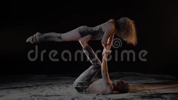 白垩纪一个长胡子的男人和一个女人表演杂技瑜伽慢动作视频的预览图