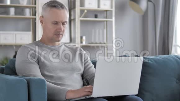 休闲白发人在笔记本电脑上的在线视频聊天视频的预览图