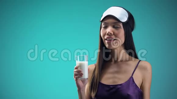 微笑的妇女喝温牛奶以改善睡眠钙和维生素视频的预览图