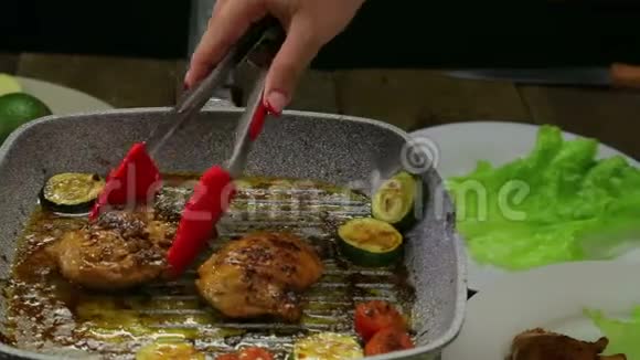 女人用手把鸡块放进一盘绿色沙拉视频的预览图