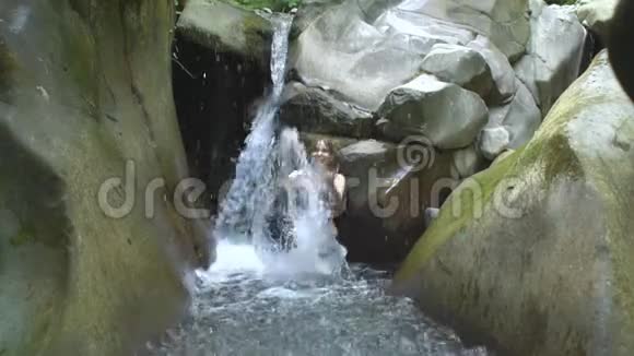 一位年轻的美女动作缓慢溅起清澈的湖水看着里面有小瀑布的镜头视频的预览图