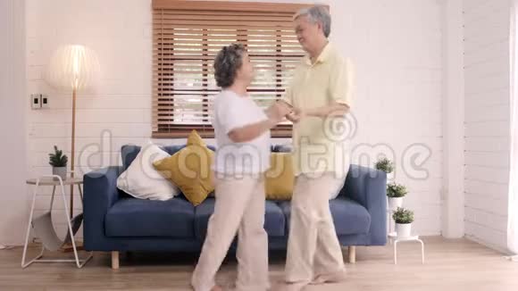 亚洲老年夫妇在家客厅听音乐时一起跳舞视频的预览图