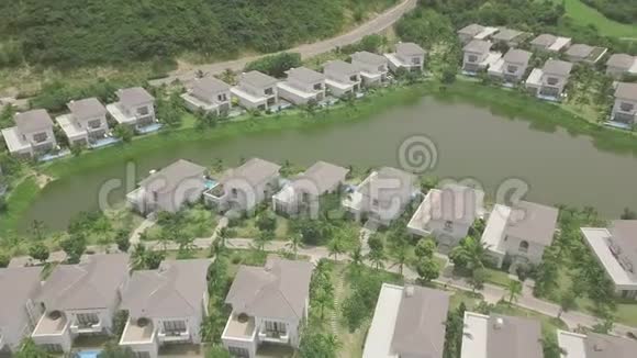 空中景观豪华别墅村有房屋游泳池和湖海岸边无障碍观景度假别墅视频的预览图