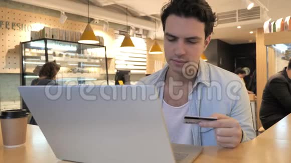 青年男子在咖啡厅网上购物信用卡视频的预览图