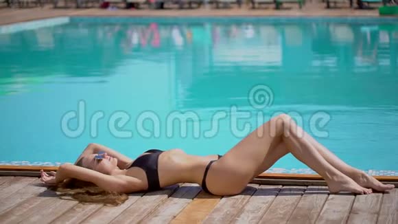 夏天美丽的年轻女子比基尼女孩在热带游泳池放松日光浴日光浴的女人视频的预览图