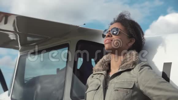 漂亮的女飞行员靠在飞机上视频的预览图