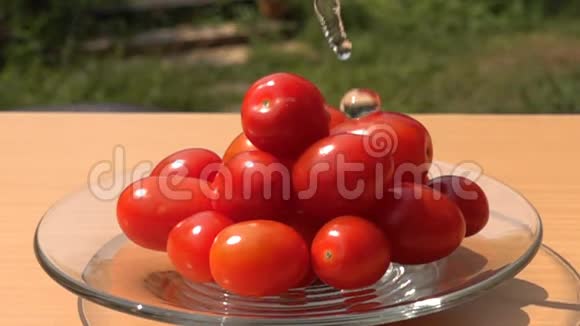 在玻璃盘子里往一堆葡萄西红柿里倒淡水视频的预览图