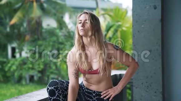 年轻女性做瑜伽运动在户外伸展身体背景是绿色植物视频的预览图
