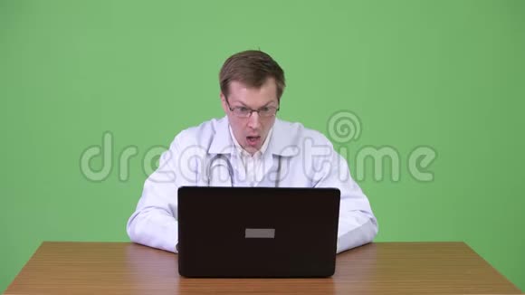 令人惊讶的医生在收到坏消息时坐着用笔记本电脑视频的预览图