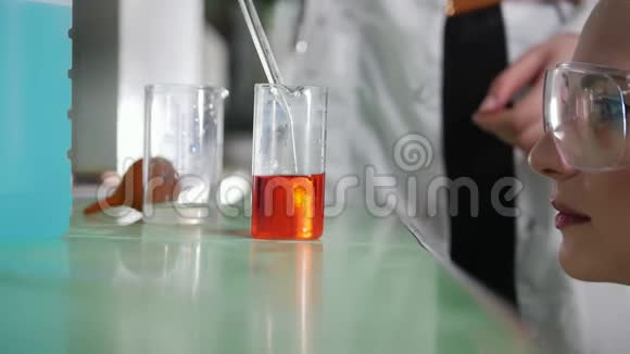 化学实验室年轻女子做实验尝试不同的化学反应视频的预览图