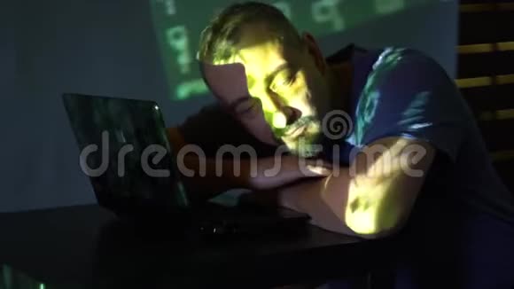 一个黑屋子里的黑客在电脑旁睡着了使用程序代码网络犯罪的概念视频的预览图