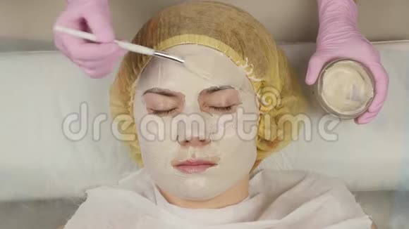 美容师把面膜敷在问题皮肤上年轻女子有皮肤清洁程序4K视频的预览图