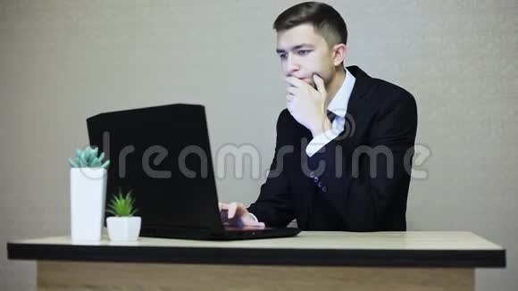 英俊的商人在办公室工作在笔记本电脑上打字视频的预览图