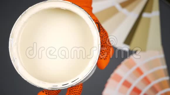 房子画家拿着一个带有米色油漆的罐子把刷子灌进去慢动作视频的预览图
