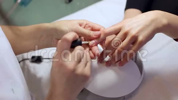 师傅在美甲沙龙指甲上涂清漆小心手视频的预览图