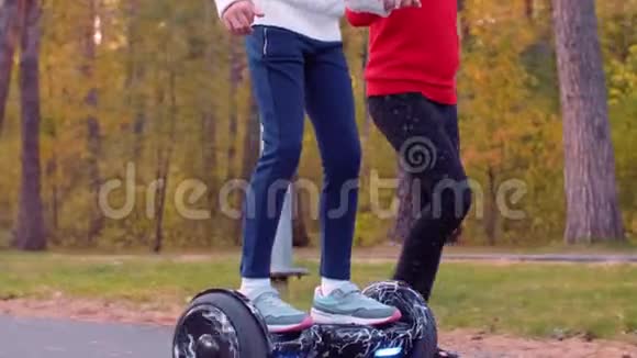 快乐的女孩在公园里和朋友牵手骑着陀螺仪视频的预览图