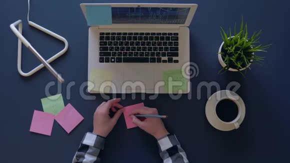 商务女性提出商业想法并把它们写在贴纸上而坐在桌子旁空中射击视频的预览图