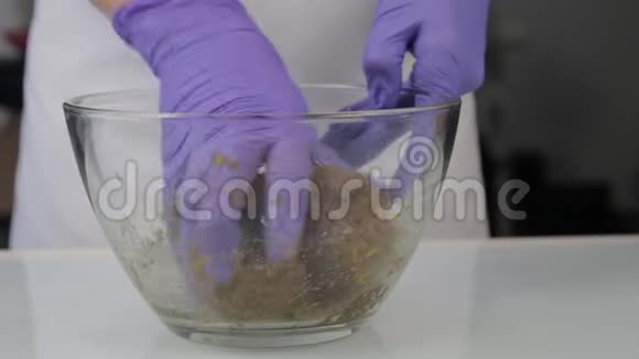 糖果师把糖果的原料混合在玻璃碗里手工制作的糖果视频的预览图