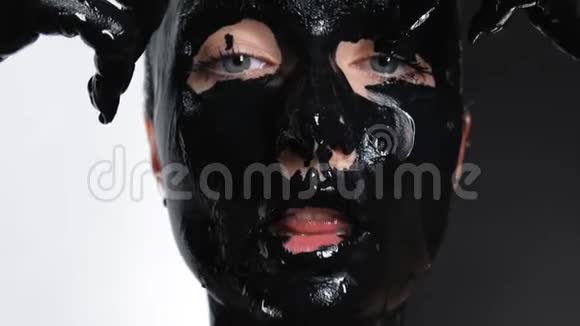 女性模特在白色背景特写应用泥面膜为面部化妆品4K视频的预览图