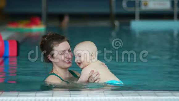 漂亮的妈妈和她的孩子在游泳池里旋转儿童发展幸福家庭视频的预览图