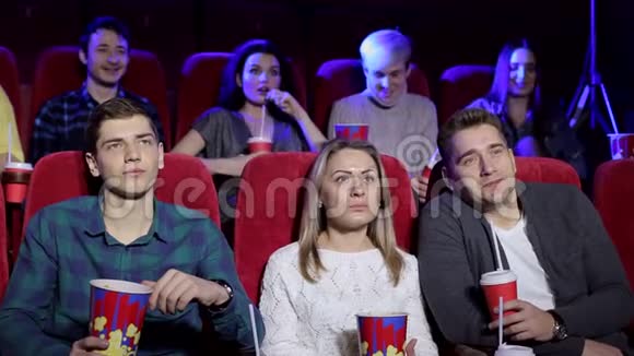 年轻人坐在电影院看电影吃爆米花视频的预览图
