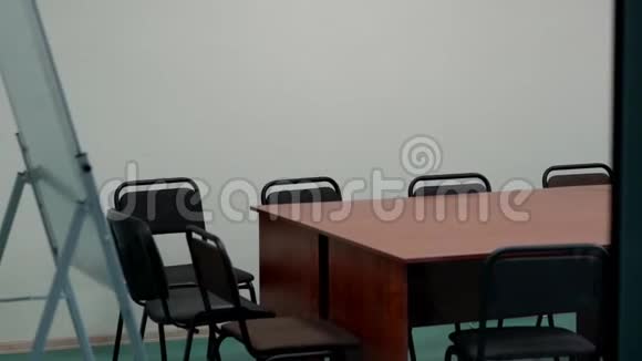 办公室的内部有木制的大桌子和许多黑色的椅子视频的预览图