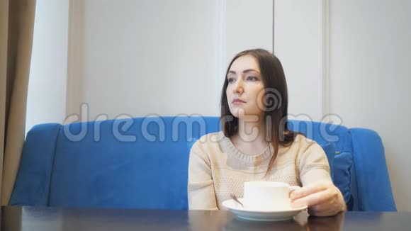 年轻漂亮的女人坐在咖啡馆里喝茶喝咖啡视频的预览图