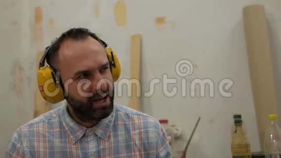 一个留着胡子的人用耳机听音乐唱歌视频的预览图